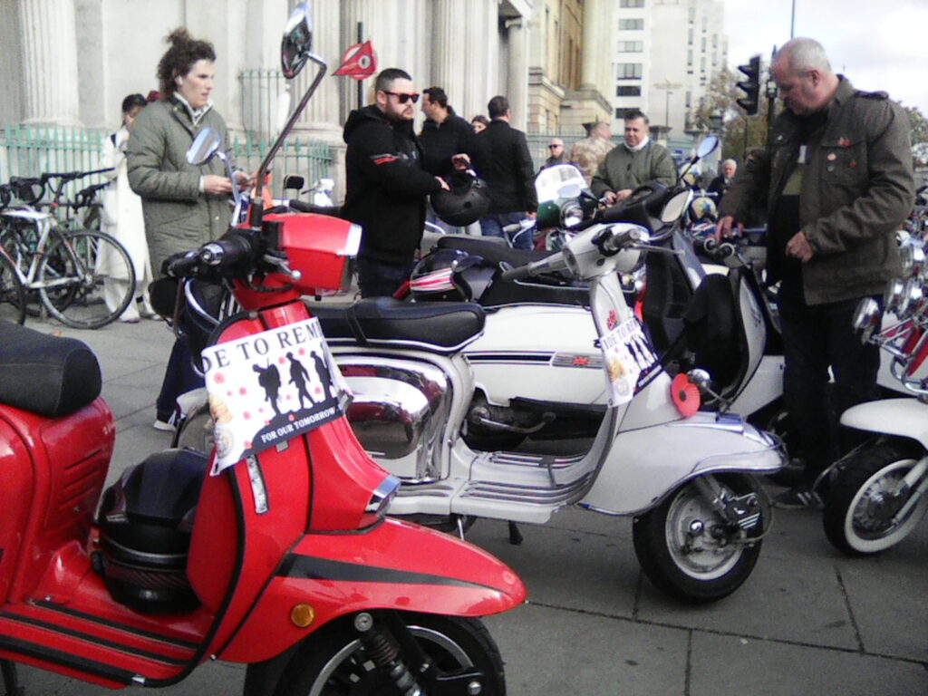Phoenix, the orange Vespa GTS, parked among the scooters at Hyde Park.